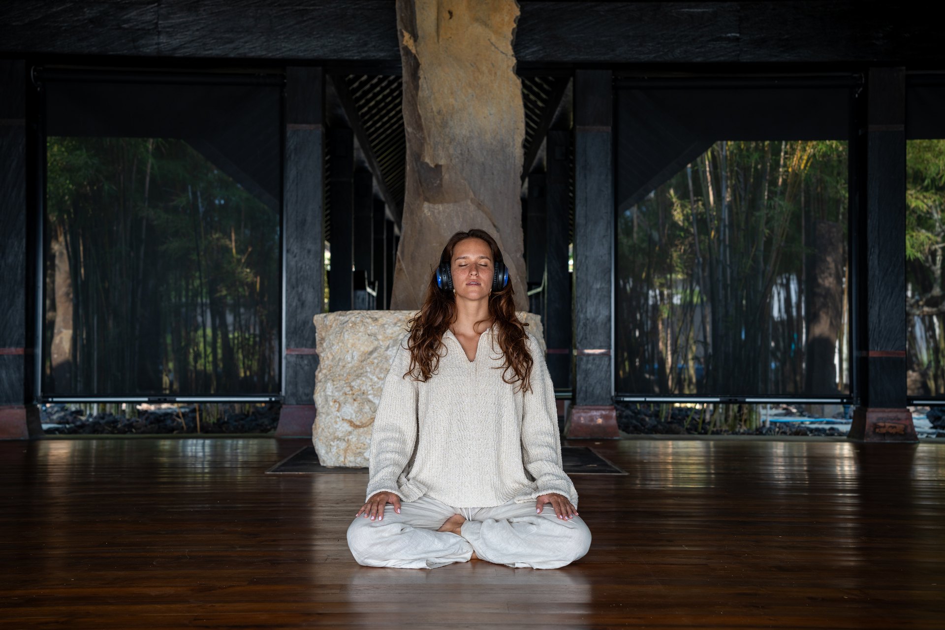 Teilnehmer liegen mit Kopfhörern auf dem Holzboden, eine Facilitatorin begleitet sanft eine 9D Breathwork Session.